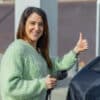 Une jeune femme qui a acheté une voiture électrique grâce au microcrédit véhicule propre
